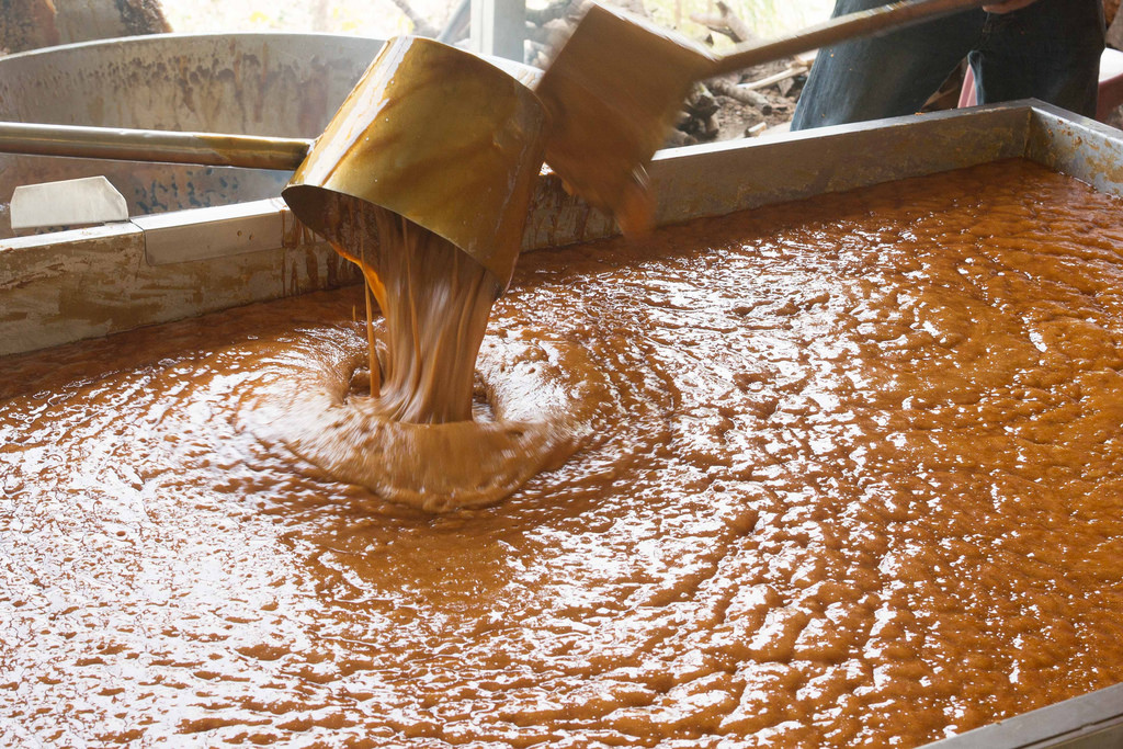 柴火下的大鍋熬煮黑糖，蔗汁在火候控制下逐漸收濃。