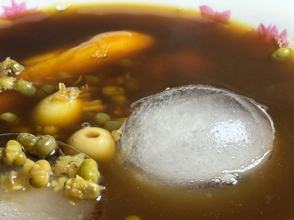 陳皮黑糖綠豆湯近照,可見綠豆、地瓜、蓮子與冰塊